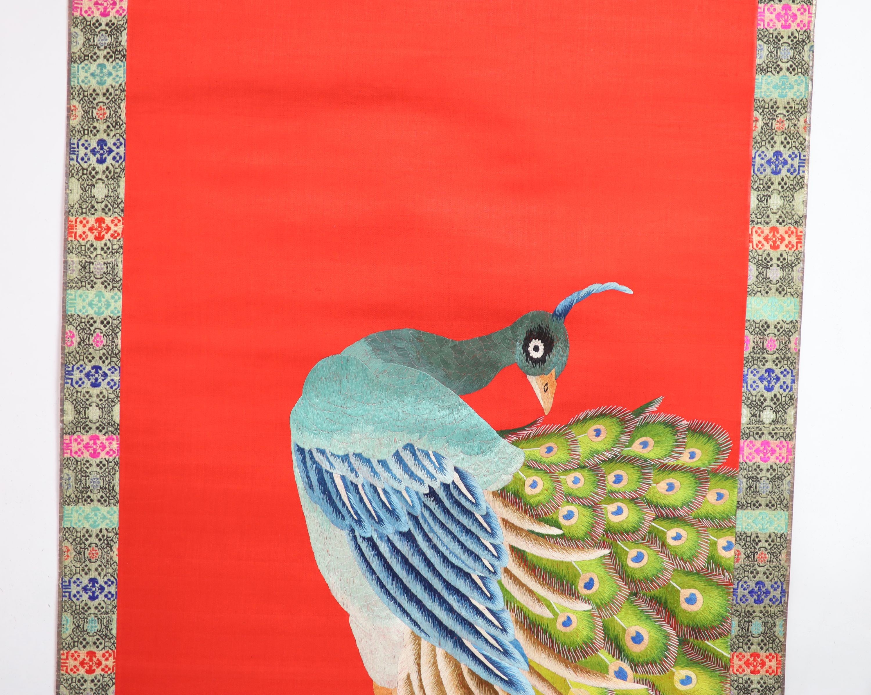 A Chinese embroidered silk ‘peacock’ scroll, late 19th century, 194 x 45 cm excluding brocade borders